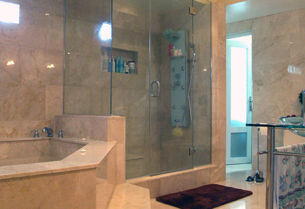 Bathroom with a bathtub, shower enclosure, and mats on the floor